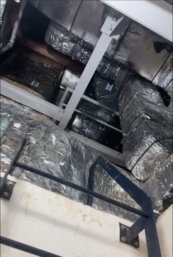 Imagem de um sistema de dutos de HVAC (aquecimento, ventilação e ar condicionado) no interior de um edifício. Os dutos estão revestidos com material isolante brilhante para melhorar a eficiência térmica.